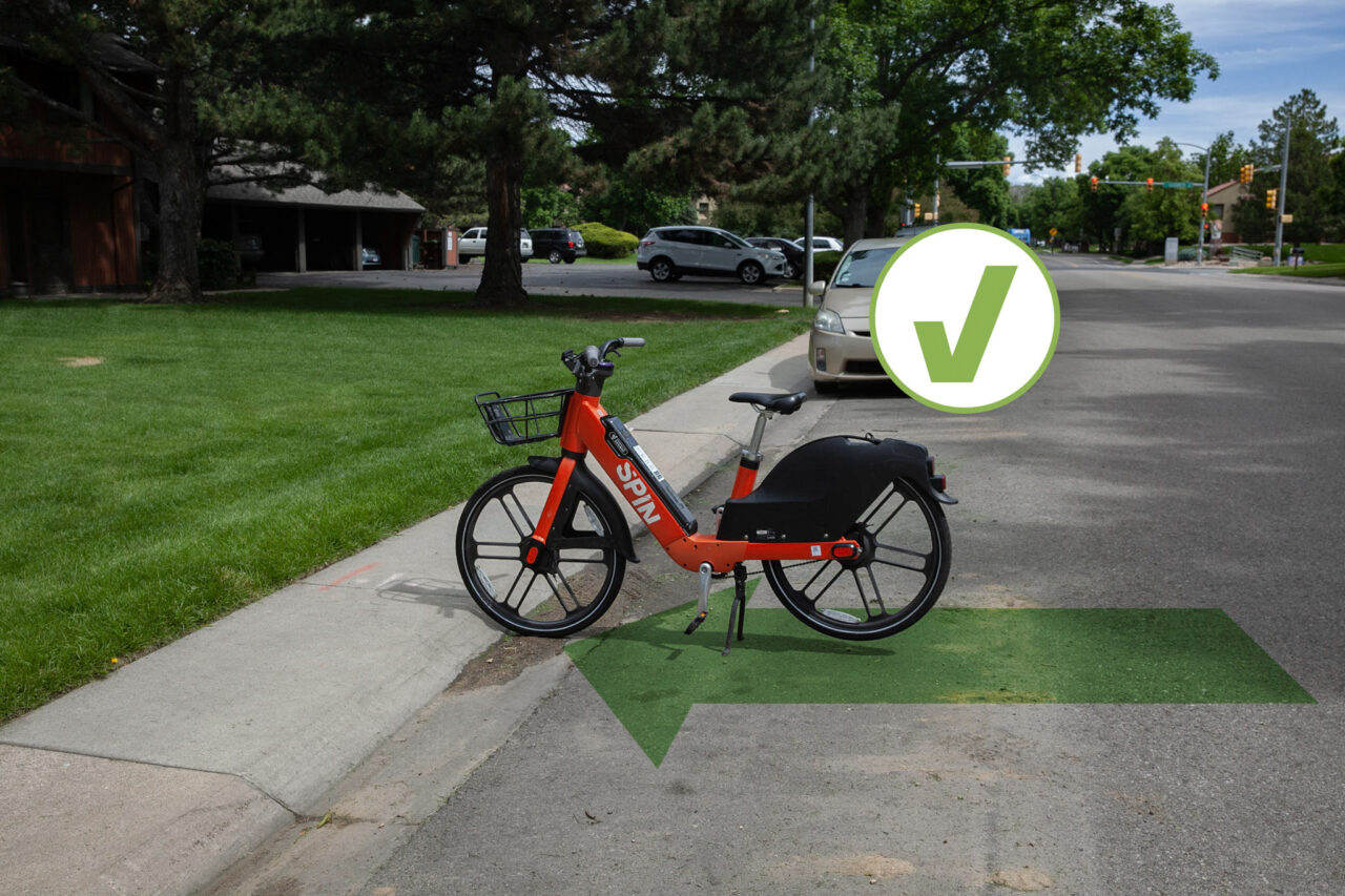 A Fort Collins Spin bike shown correctly parked in an undesignated street location.