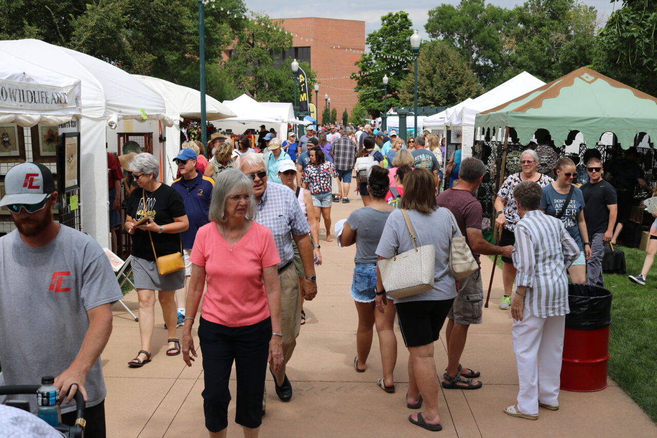 Shoppers browse booths lining outdoor walkways.