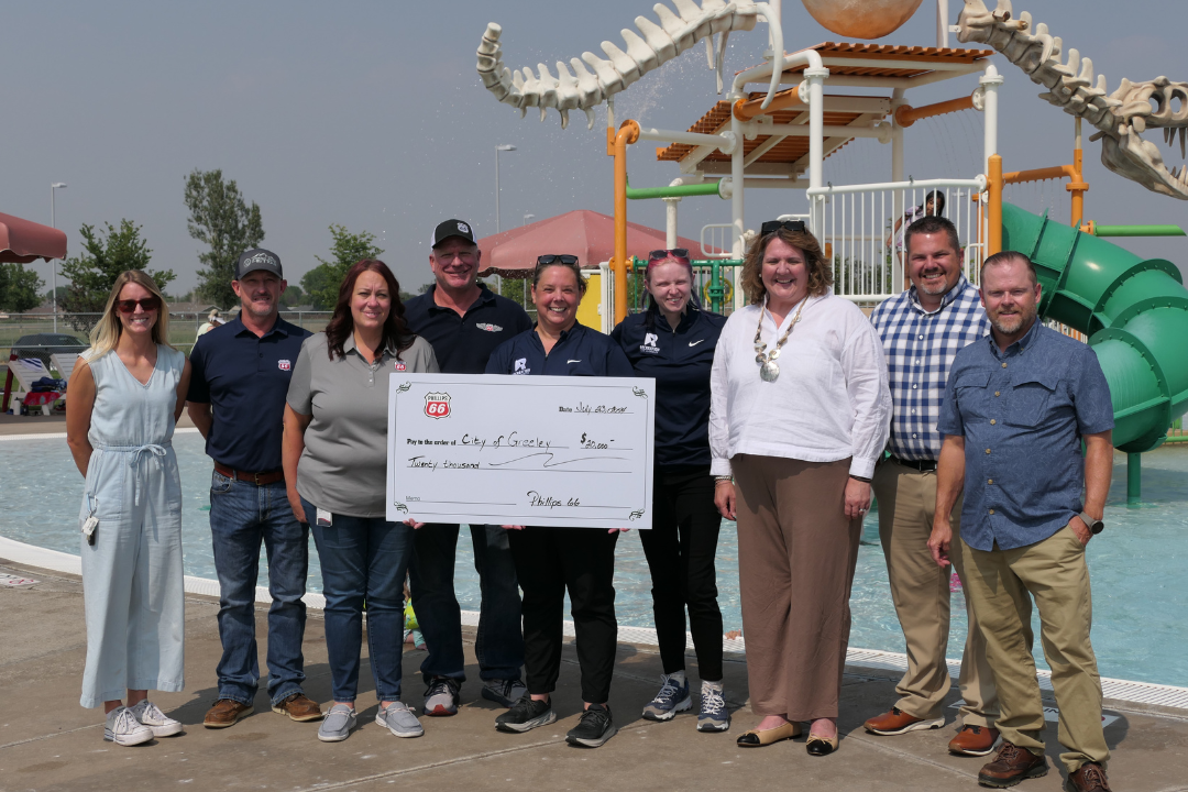 Kelly McClanahan, City of Greeley Recreation aquatics supervisor, holds a check for $20,000 at the Discovery Bay Waterpark in Greeley. Phillips 66 presented the check to the recreation division for swimming lessons and aquatics equipment and technology upgrades.