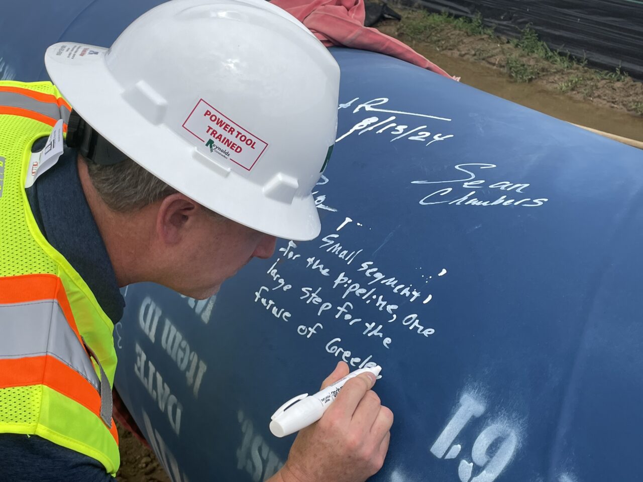 A man writes an inscription on a pipeline.