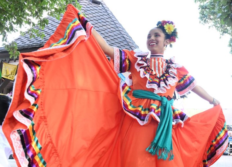 A dancer twirls her long skirt as part of a group of Mexican dancers on the plaza at Centennial Village Museum.