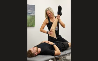 A physical therapist stretching a man's leg.