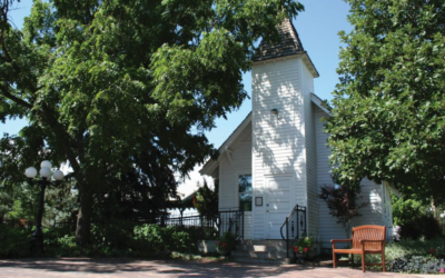 White clapboard church surrounded by trees.