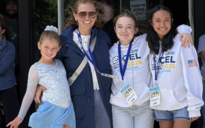 Coach Ludy poses with three Ice Haus figure skaters at a National competition in Massachusetts.