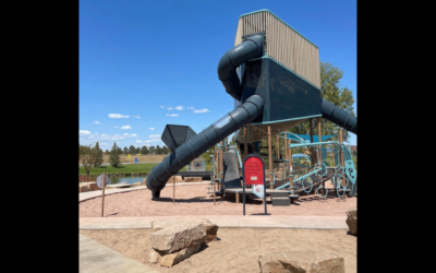 A multi-story playground feature with a slide stands prominently above a play space.