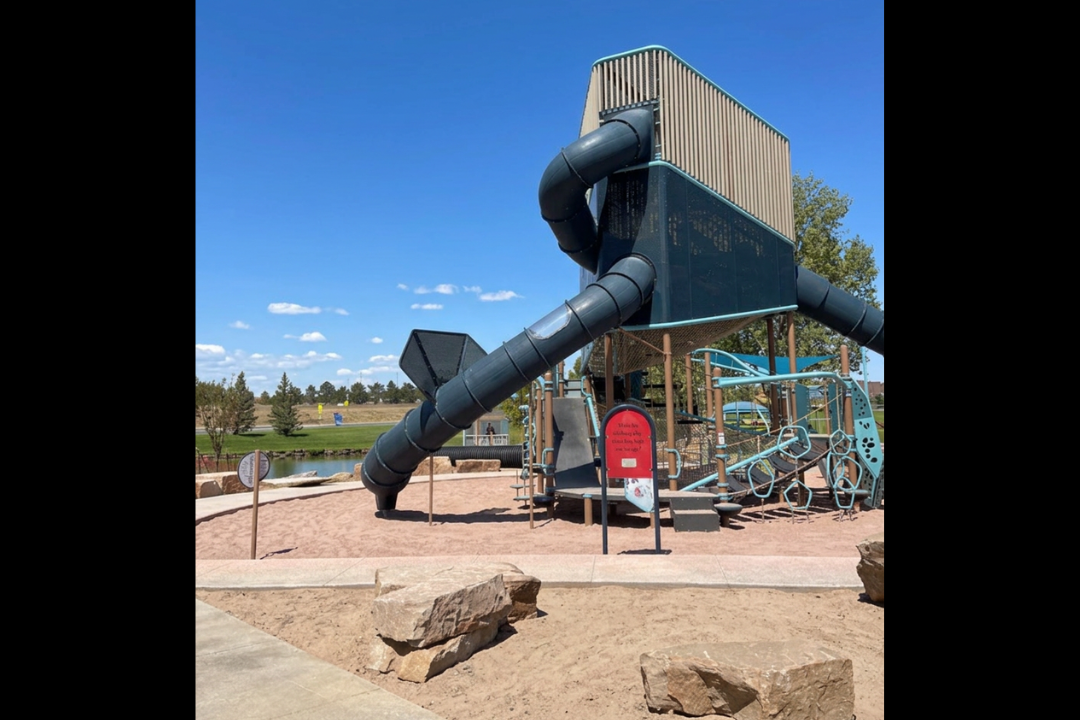 Adaptive Twin Rivers Playground in Greeley A multi-story playground feature with a slide stands prominently above a play space.
